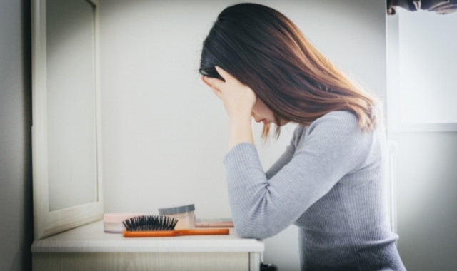 頭を抱えるようにうつむく妻