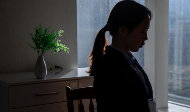暗い部屋で佇んでいる女性