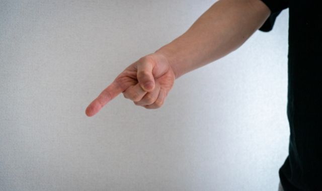 何かに対して怒って非難する男性