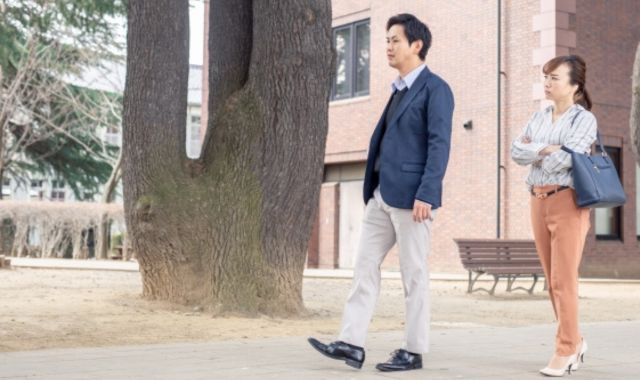 不満げに夫を追いかける妻