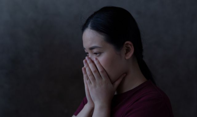 暗がりで驚愕する女性