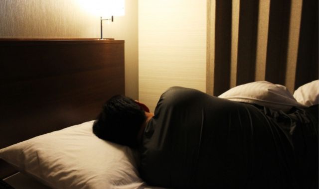 背中を向けて寝ている男性
